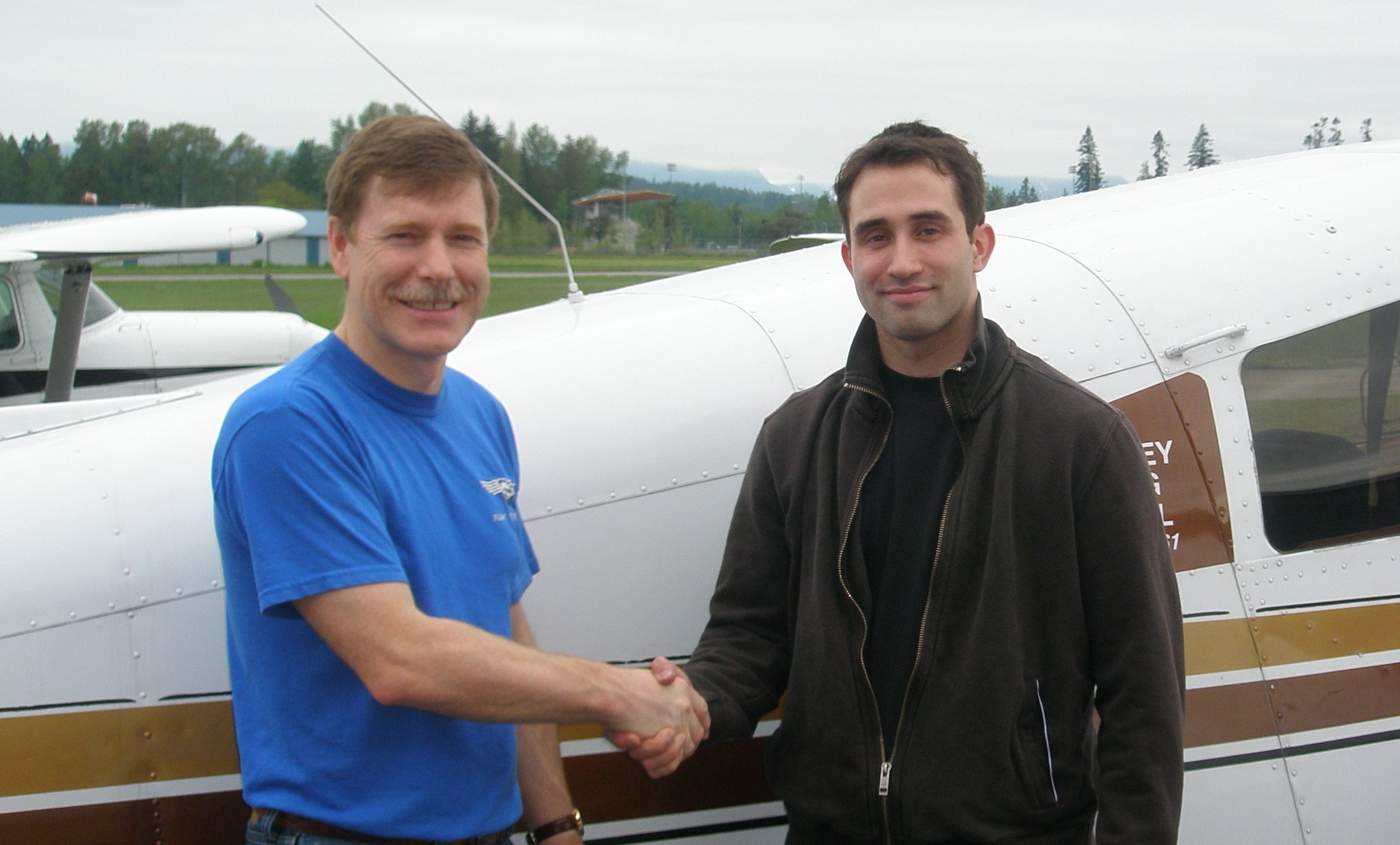 Shadrin Storness-Bliss receives contratulations from Flight Instructor Peter Waddington after the successful completion of Shad's Commercial Pilot Flight Test on May 15, 2008.  Langley Flying School.